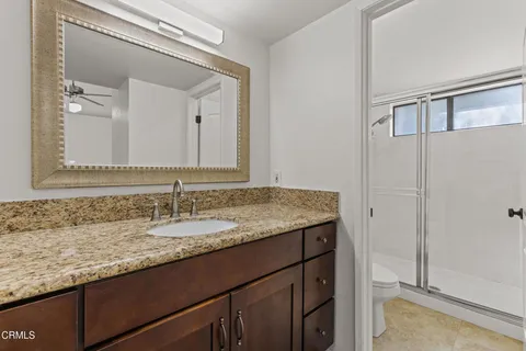a bathroom with a granite countertop sink and a mirror