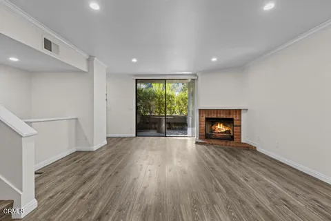 an empty room with wooden floor and fireplace