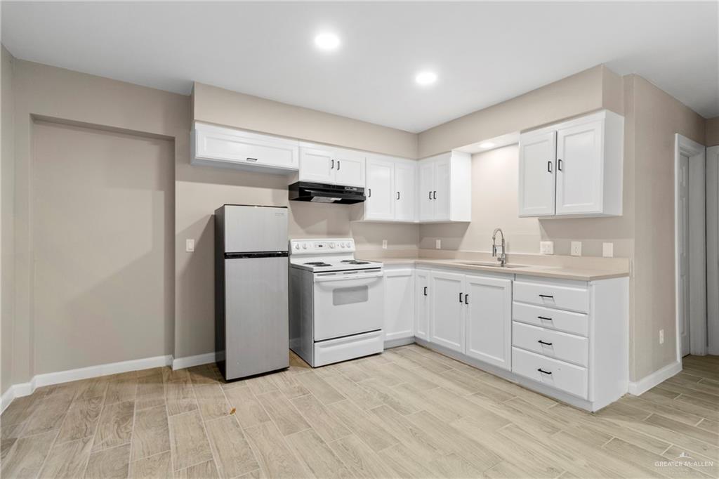 712 Toronto Avenue McAllen, TX 78503 - Photo 4 of 13 a kitchen with white cabinets and white appliances