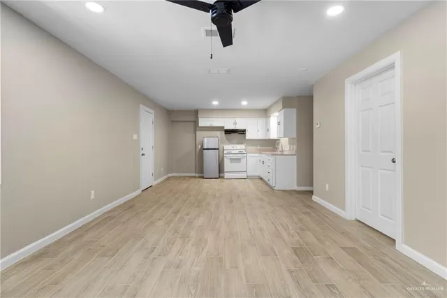 a view of a kitchen with a sink and dishwasher a refrigerator with wooden floor