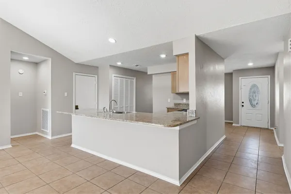 a large white kitchen with a sink and dishwasher