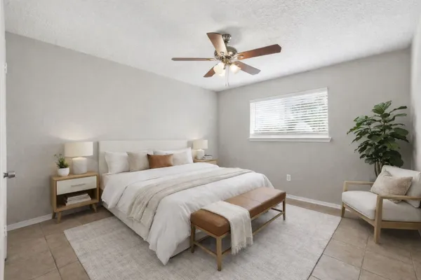 a spacious bedroom with a bed and a chandelier