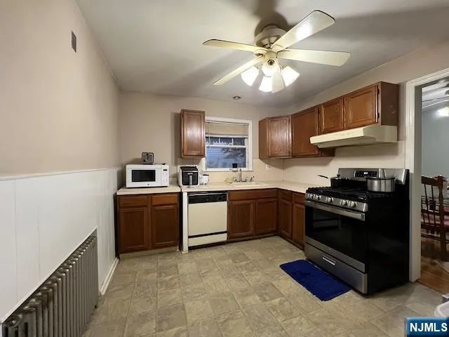 a kitchen with granite countertop stainless steel appliances and wooden cabinets
