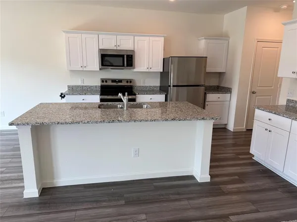 a large kitchen with granite countertop a large counter top and sink