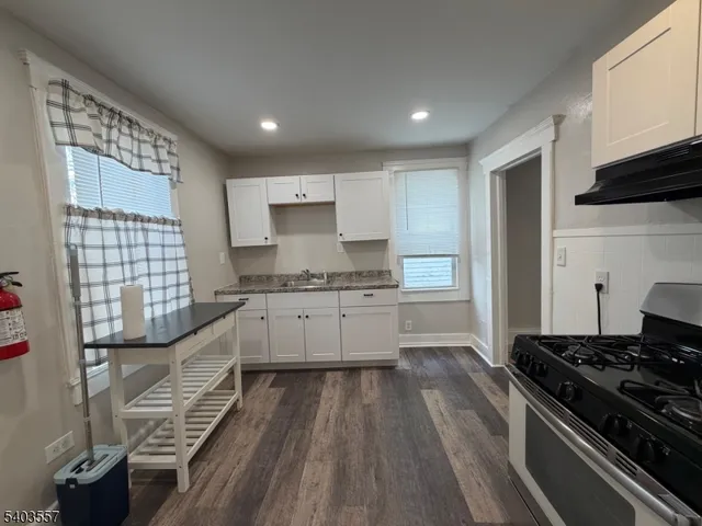 a kitchen with granite countertop a stove and a sink