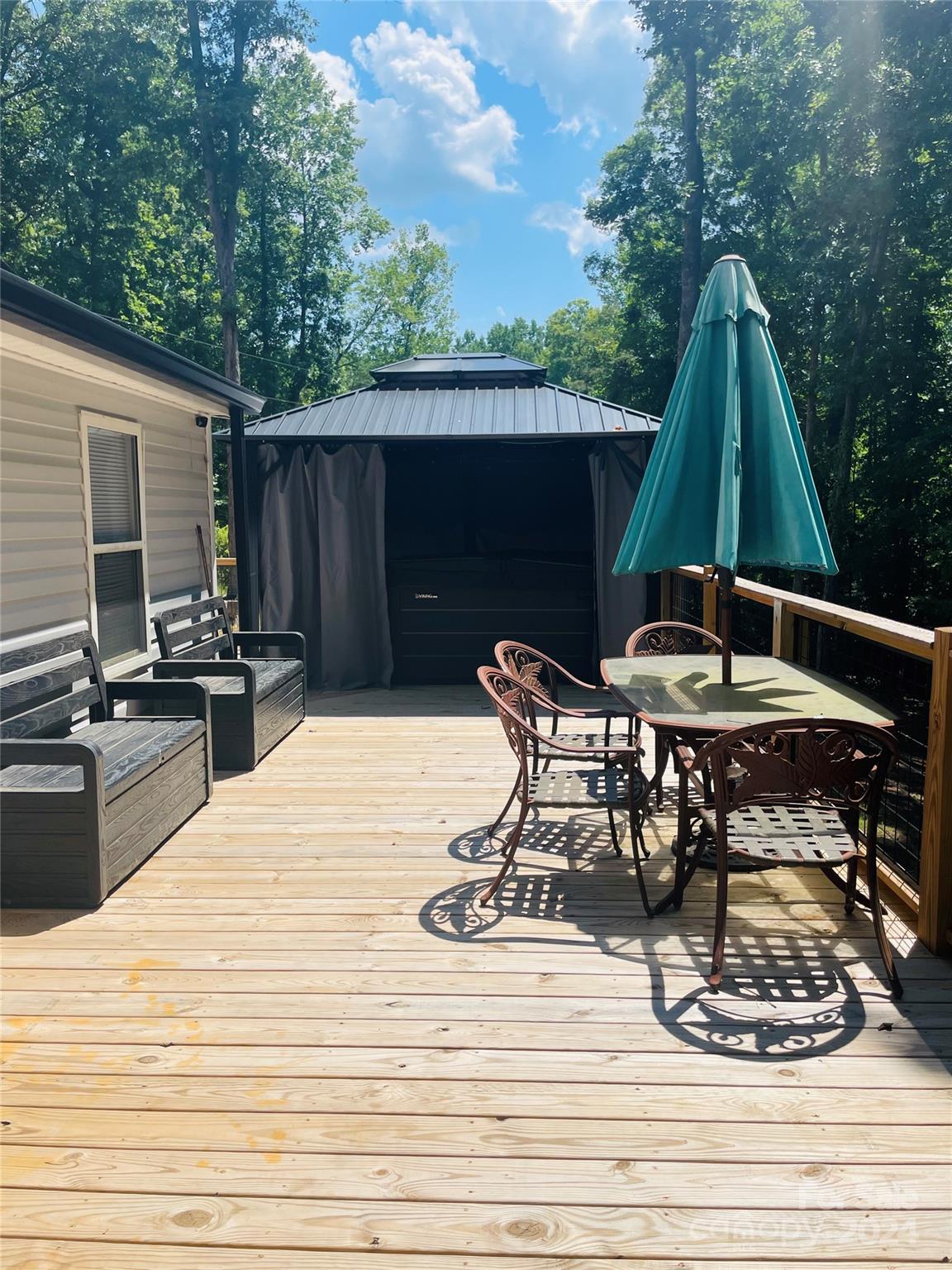 191 Old Hearth Road, Unit 29 Clover, SC 29710 - Photo 3 of 21 a view of a backyard with table and chairs with wooden floor and fence