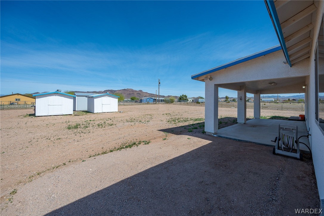 3411 West Carmichael Road Golden Valley, AZ 86413 - Photo 44 of 97 View of yard featuring a storage shed and a patio