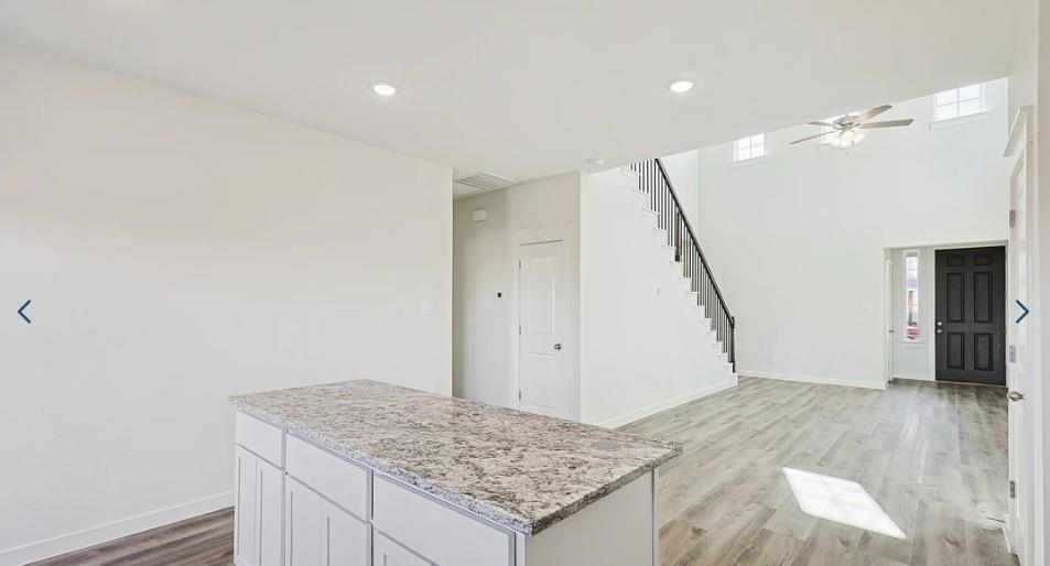 520 Weller Road McKinney, TX 75069 - Photo 12 of 12 Kitchen featuring a ceiling fan, a center island, open floor plan, light wood-style flooring, and baseboards