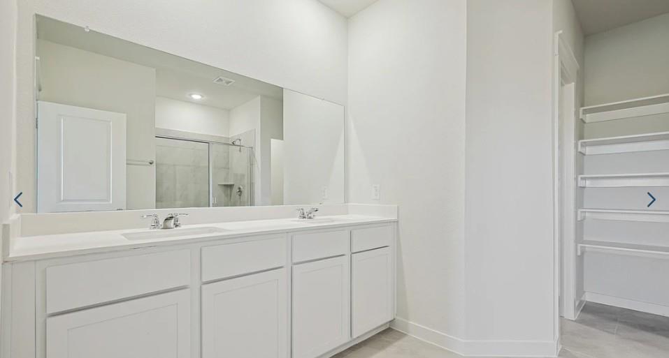 520 Weller Road McKinney, TX 75069 - Photo 6 of 12 Full bathroom featuring a stall shower, double vanity, baseboards, and tile patterned flooring