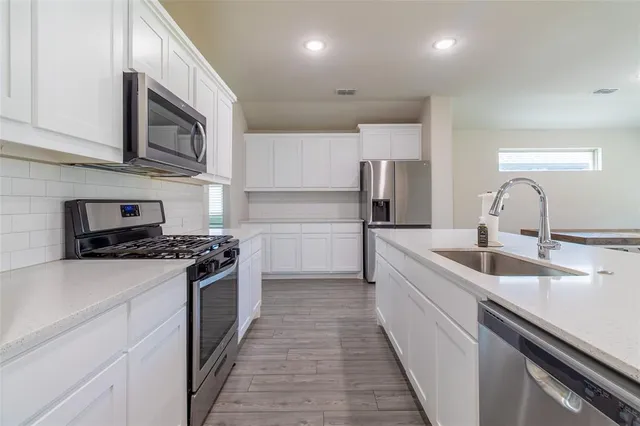 a kitchen with stainless steel appliances granite countertop a sink and a stove