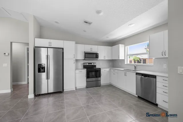 a kitchen with stainless steel appliances granite countertop a refrigerator and a stove top oven