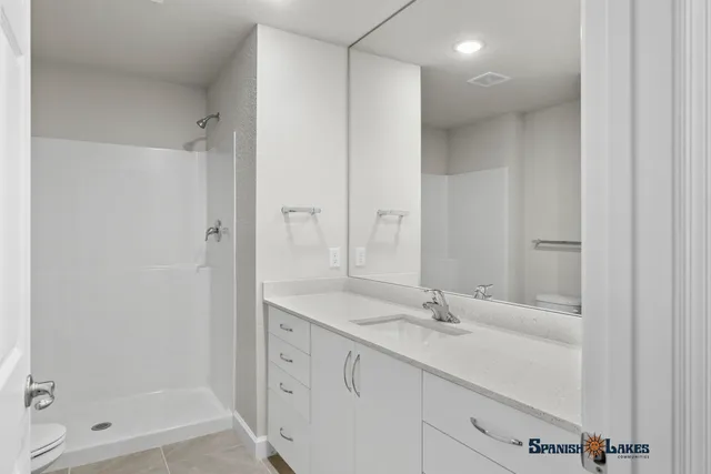a bathroom with a shower sink and mirror