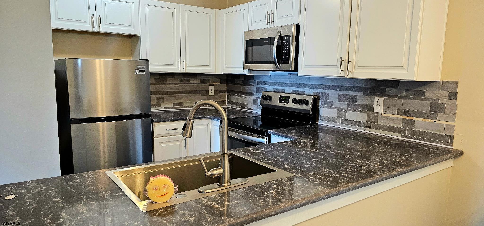 160 Heather Croft, Unit 160 Egg Harbor Township, NJ 08234 - Photo 3 of 12 a kitchen with stainless steel appliances granite countertop a refrigerator a stove and a sink