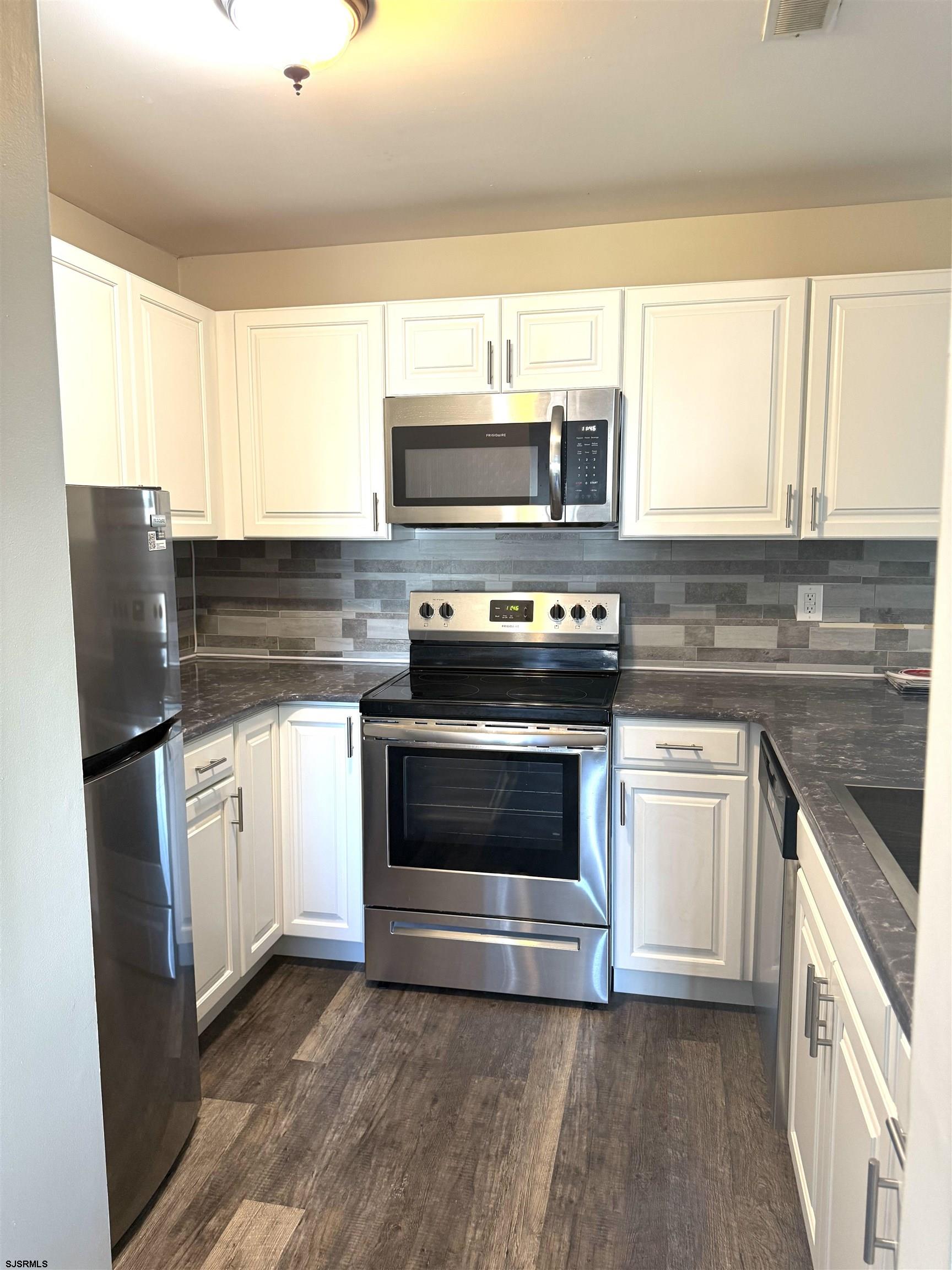 160 Heather Croft, Unit 160 Egg Harbor Township, NJ 08234 - Photo 5 of 12 a kitchen with granite countertop a stove top oven microwave and refrigerator