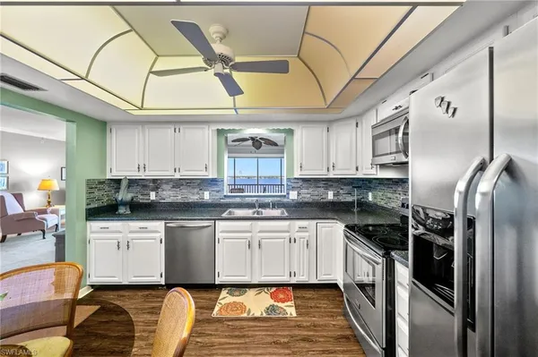 a kitchen with stainless steel appliances granite countertop a sink a stove and refrigerator