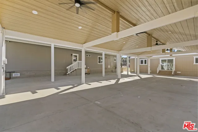 a view of a big room with wooden floor and windows