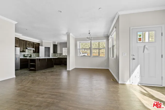 a kitchen with stainless steel appliances granite countertop a refrigerator a stove a sink and white cabinets with wooden floor