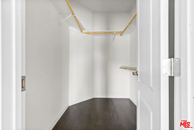 an empty room with ceiling fan and windows