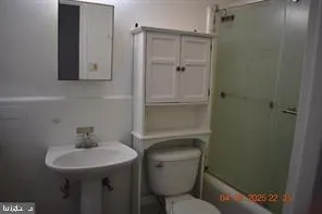 a bathroom with a toilet a sink and mirror