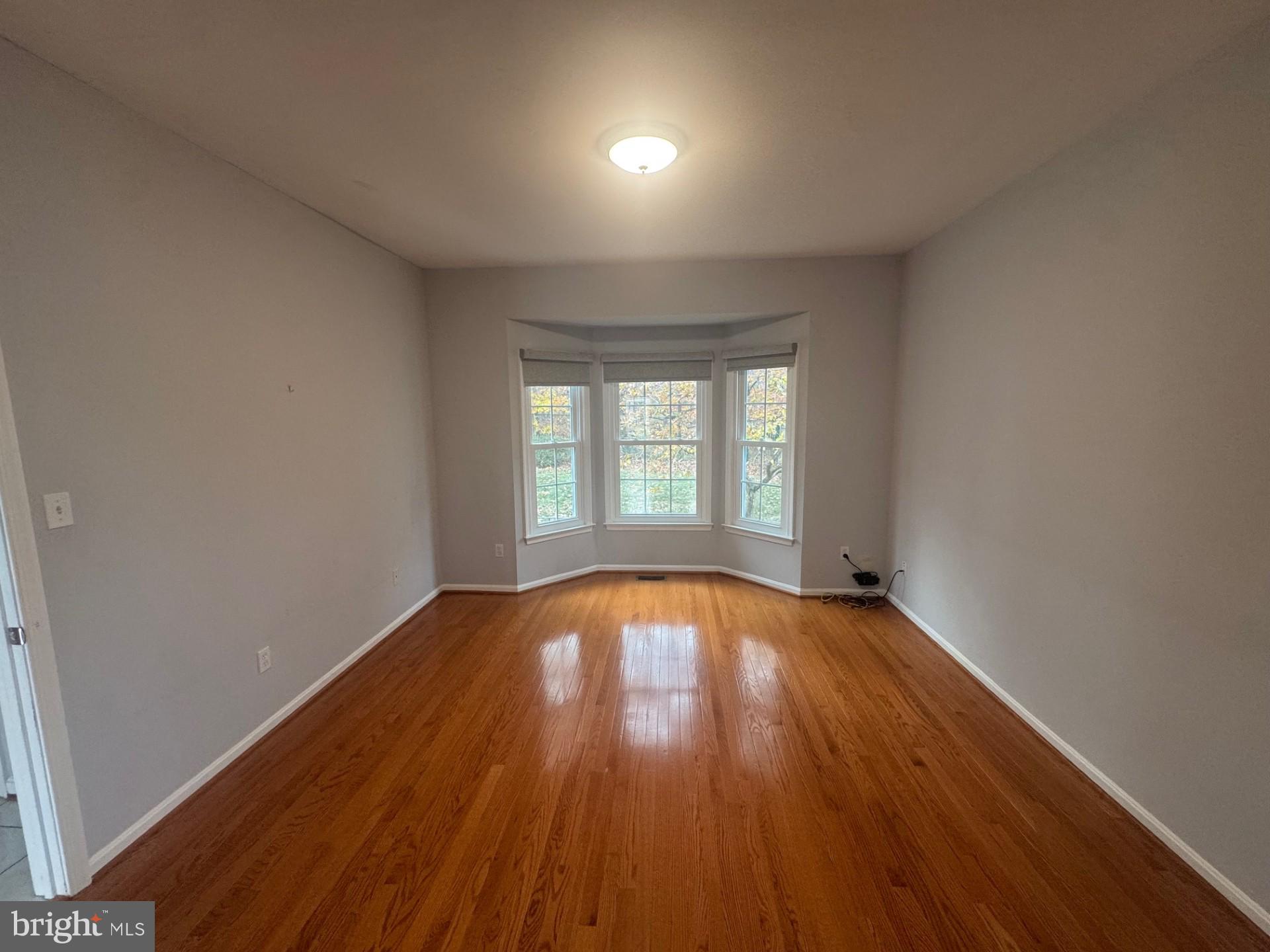 8143 Ridge Creek Way Springfield, VA 22153 - Photo 4 of 42 an empty room with wooden floor and windows