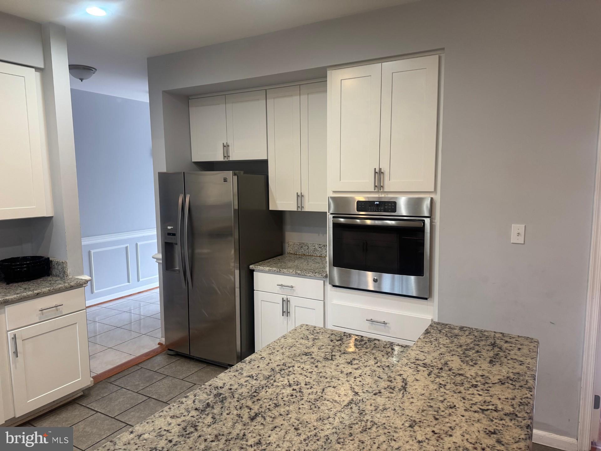 8143 Ridge Creek Way Springfield, VA 22153 - Photo 9 of 42 a kitchen with a refrigerator and a stove top oven
