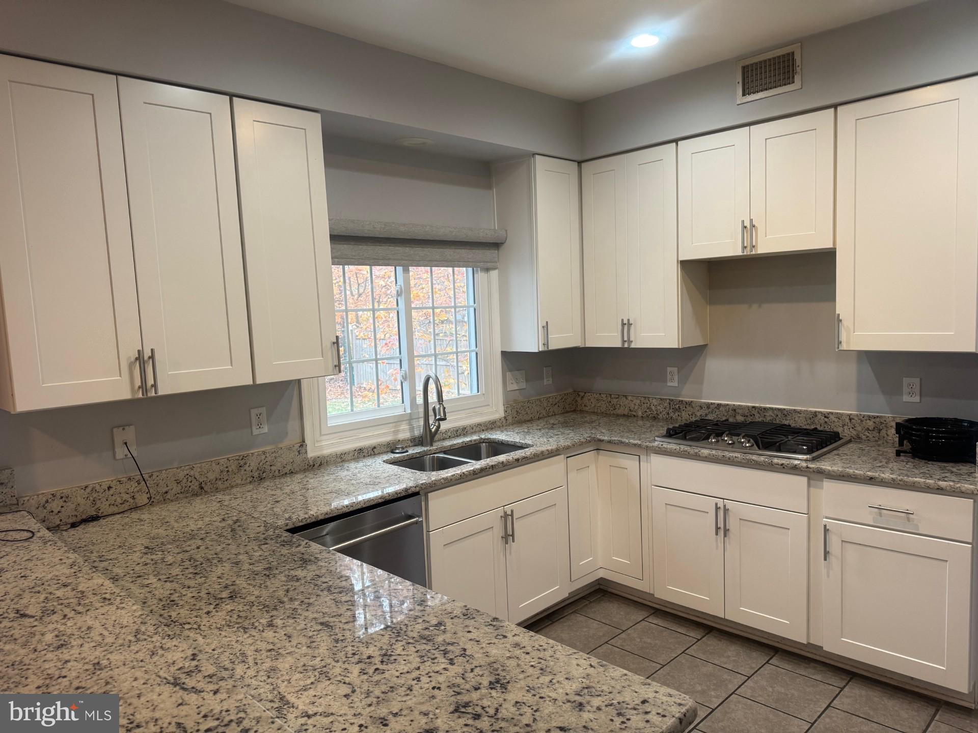 8143 Ridge Creek Way Springfield, VA 22153 - Photo 10 of 42 a kitchen with granite countertop a sink a stove and cabinets