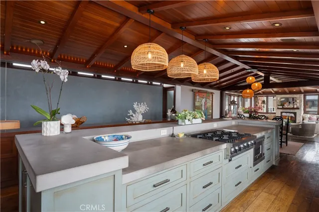 a large kitchen with stainless steel appliances granite countertop a stove a sink dishwasher a dining table and chairs with wooden floor