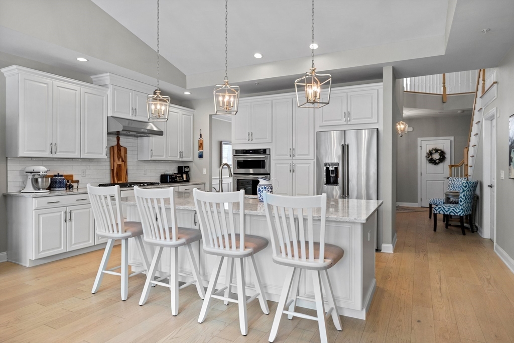 57 Phoebe Street, Unit 33 Methuen, MA 01844 - Photo 14 of 41 a kitchen with stainless steel appliances kitchen island granite countertop a table chairs and a refrigerator