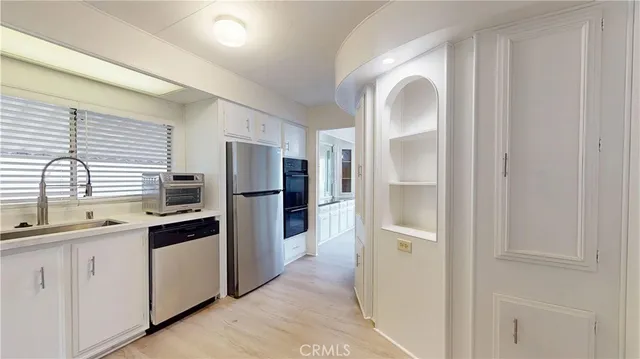 a kitchen with stainless steel appliances granite countertop a refrigerator and a sink