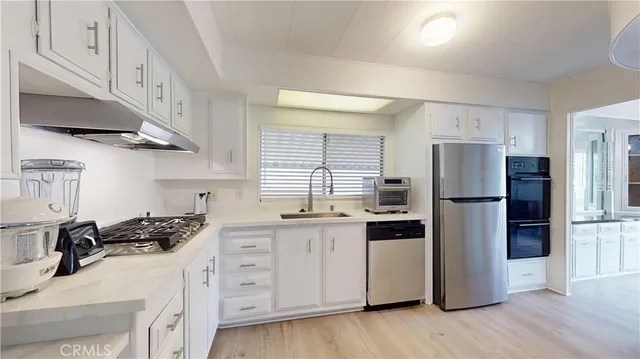 a kitchen with stainless steel appliances a refrigerator sink and cabinets