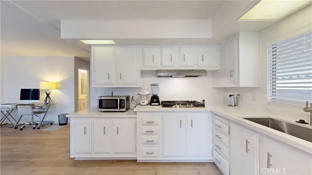 a kitchen with white cabinets and appliances
