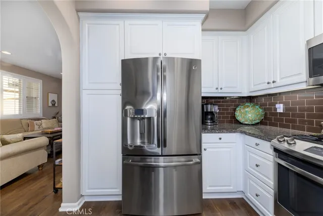 a kitchen with stainless steel appliances granite countertop a refrigerator sink and stove