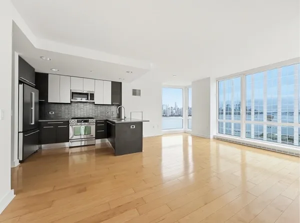a large kitchen with a large counter top stainless steel appliances and cabinets