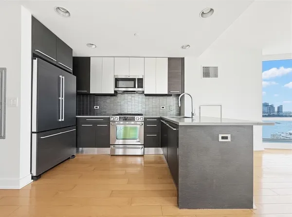 a kitchen with stainless steel appliances a refrigerator sink and white cabinets
