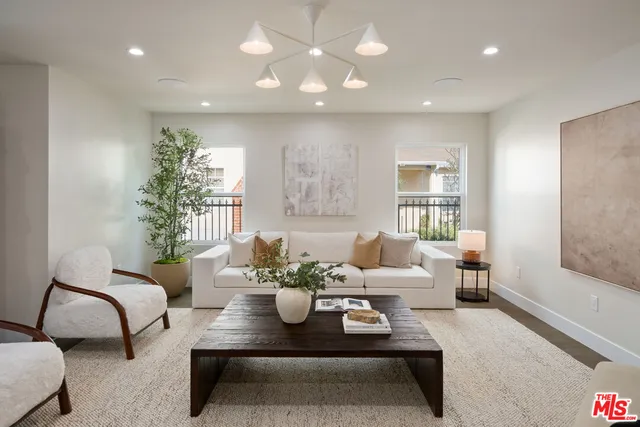 a living room with furniture and potted plants