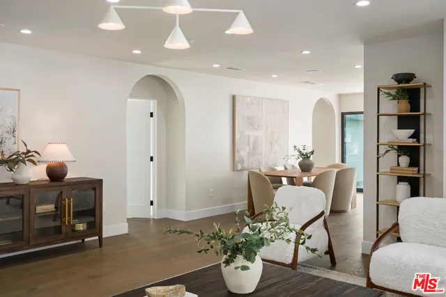 a kitchen with a table a stove a sink dishwasher and cabinets with wooden floor