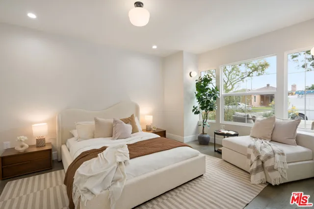 a bedroom with a bed and a potted plant