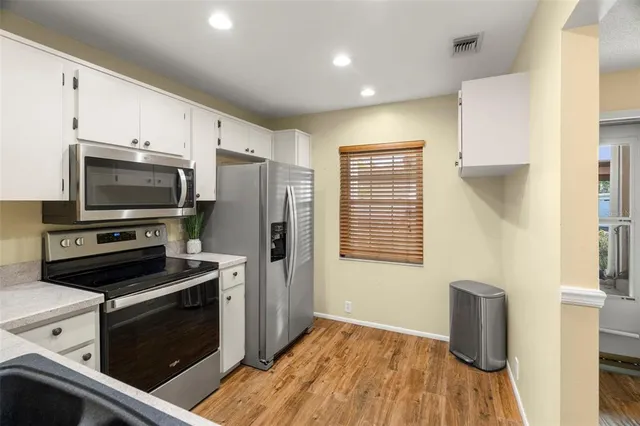 a kitchen with granite countertop a refrigerator stove and microwave