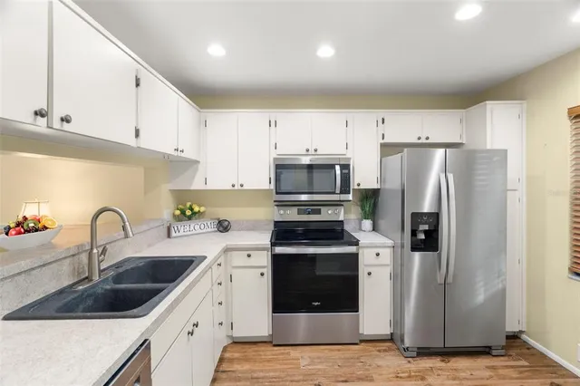a kitchen with refrigerator a sink and cabinets