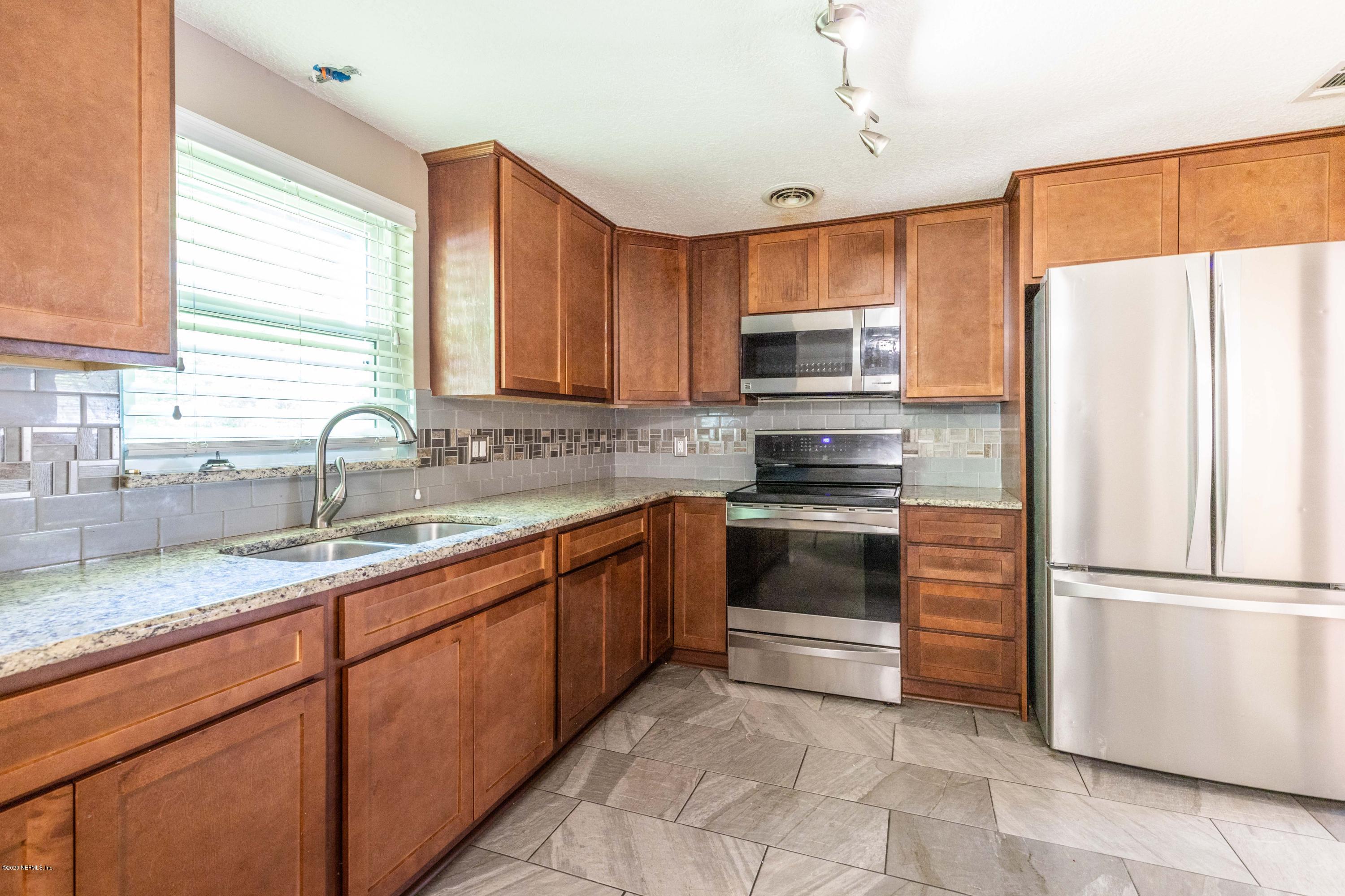 5908 Ensenada Road Jacksonville, FL 32244 - Photo 15 of 30 a kitchen with granite countertop a refrigerator sink and microwave
