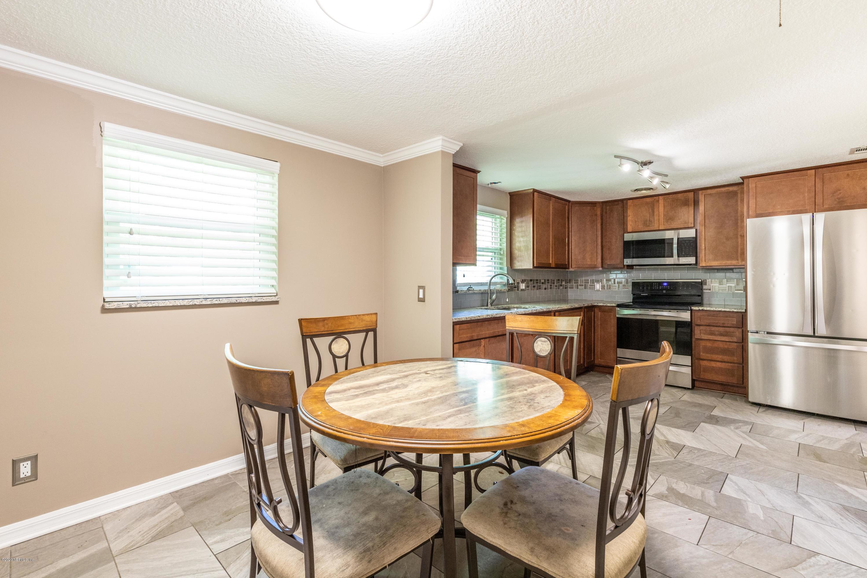 5908 Ensenada Road Jacksonville, FL 32244 - Photo 17 of 30 a kitchen with stainless steel appliances granite countertop a dining table chairs refrigerator and a sink