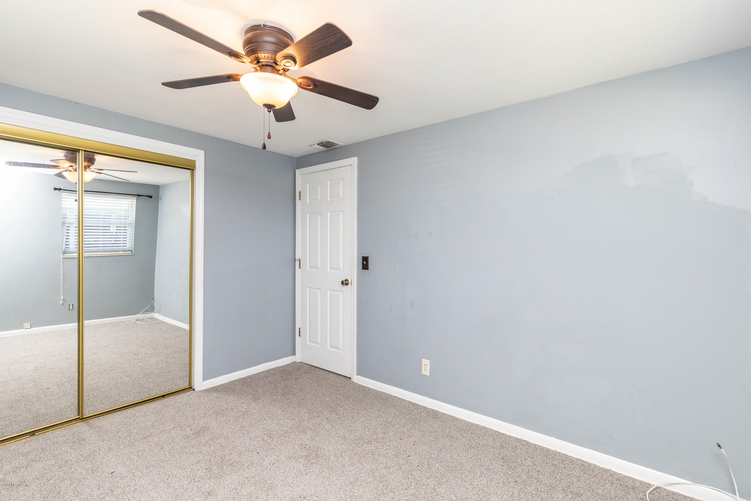 5908 Ensenada Road Jacksonville, FL 32244 - Photo 23 of 30 an empty room with a ceiling fan and a window
