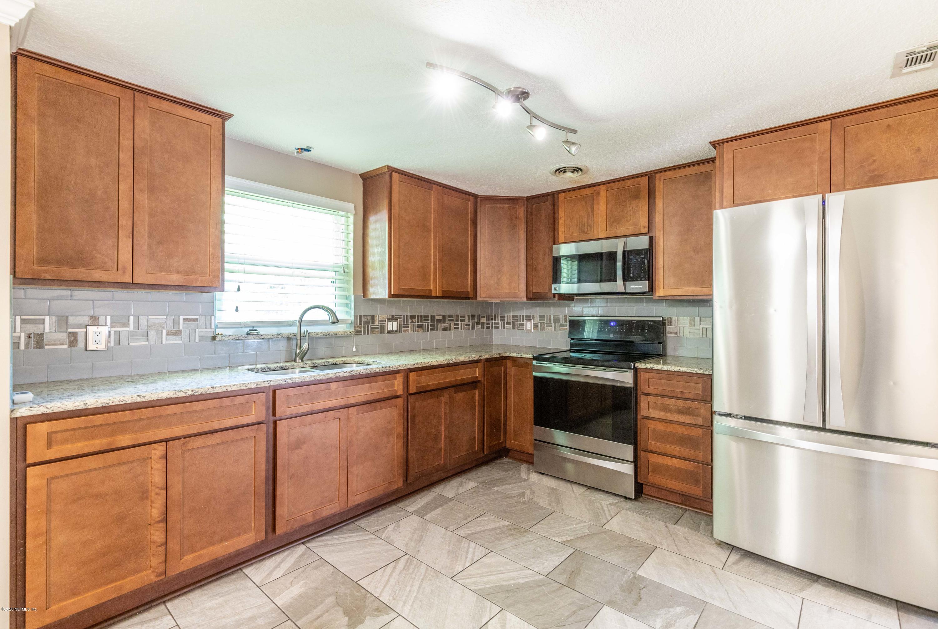 5908 Ensenada Road Jacksonville, FL 32244 - Photo 4 of 30 a kitchen with stainless steel appliances granite countertop a refrigerator stove a sink dishwasher and microwave