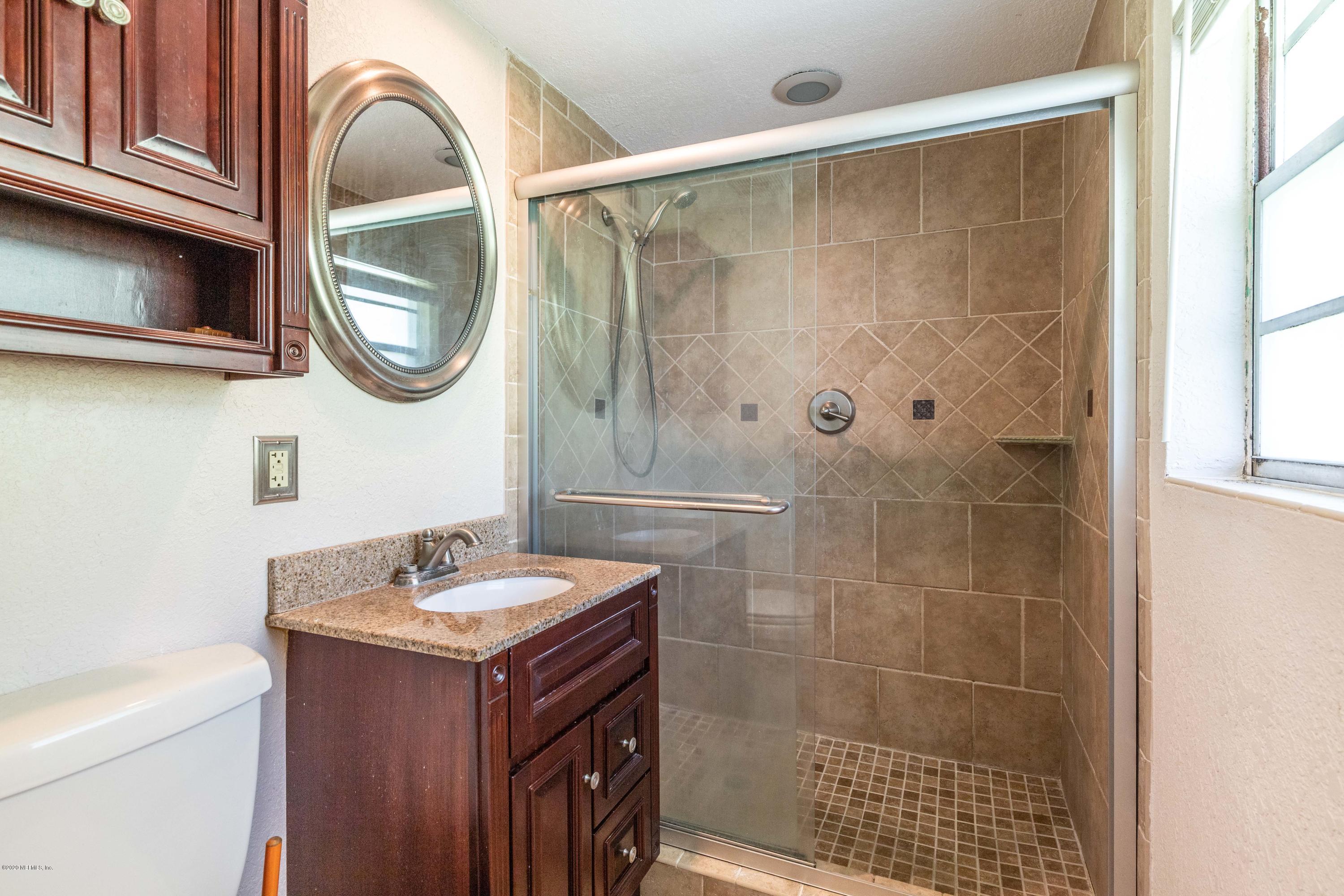 5908 Ensenada Road Jacksonville, FL 32244 - Photo 7 of 30 a bathroom with a sink a mirror a toilet and a shower