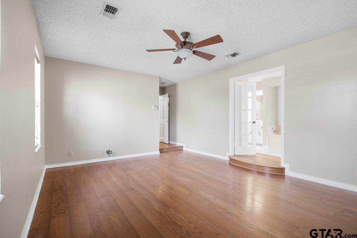 15938 Big Oak Bay Road Tyler, TX 75707 - Photo 10 of 21 an empty room with wooden floor and windows