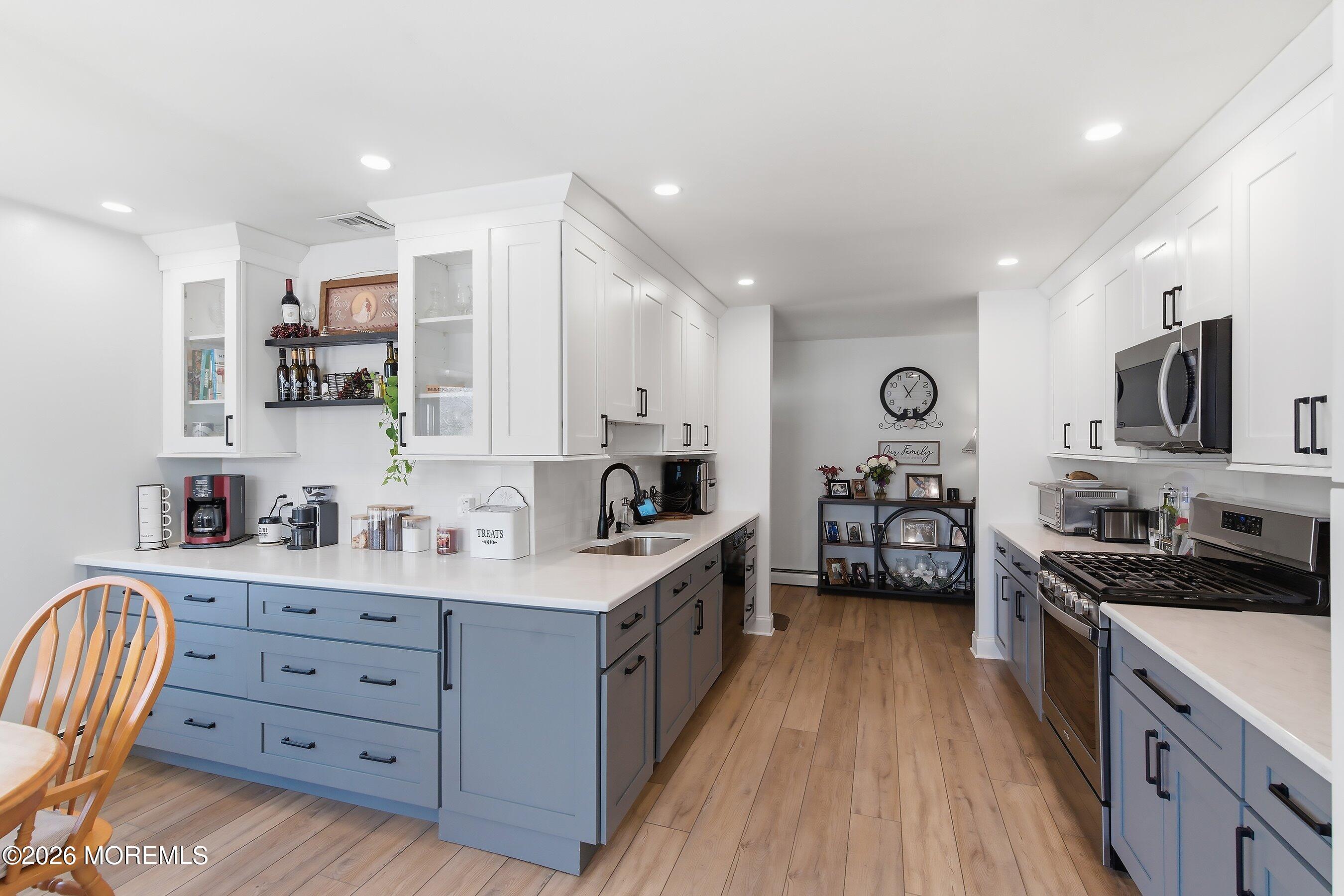 745 Oak Glen Road Howell, NJ 07731 - Photo 18 of 46 a large kitchen with stainless steel appliances granite countertop a lot of counter space and wooden floors