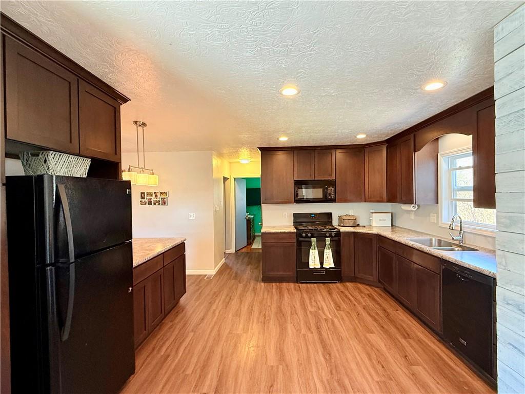 2459 Doc Walker Road Parker, PA 16049 - Photo 3 of 18 a kitchen with stainless steel appliances wooden floor a refrigerator and a sink