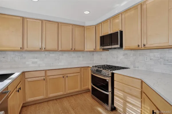 a kitchen with granite countertop cabinets stainless steel appliances and wooden floor