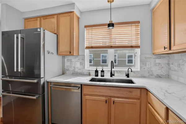a kitchen with stainless steel appliances granite countertop a refrigerator and a sink