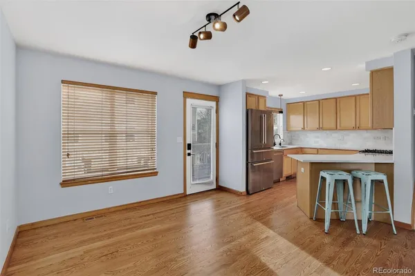 a kitchen with a refrigerator and a stove top oven